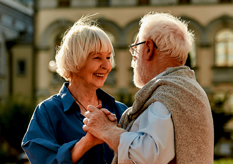 Ein älteres Pärchen lacht und tanzt